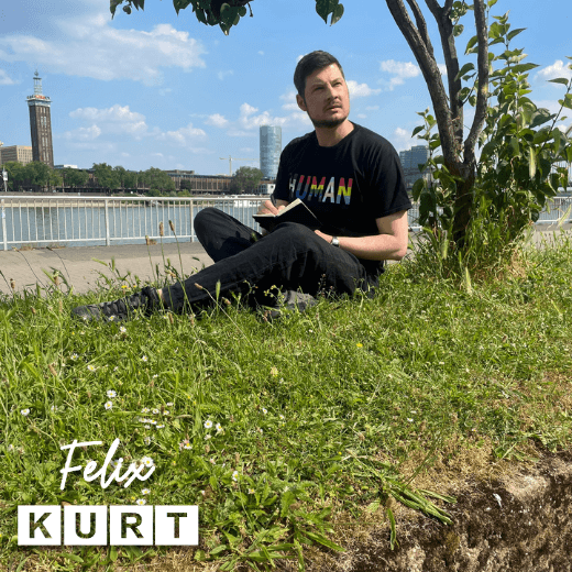 Photo of gay LGBTQ+ queer author Felix Kurt sitting on a riverbank writing for his blog